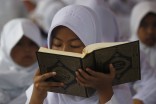 A girl practices reading the Koran in Jakarta. More than 1,400 children gathered at a park in Indonesia to read the Koran to mark the holy month of Ramadan, which start Friday. (Photo from REUTERS/Supri)