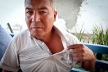 An oil worker shows the scar where he says he was shot by police during protests in Zhanouzen last December (Photo by Alex Stonehill)