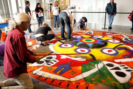 Artist Victor Gonzalez helped assemble a sand carpet designed by Oaxacan artist Fulgencio Lazo, following the Dia de los Muertos tradition of his region of Mexico. (Photo by Liliana Caracoza)