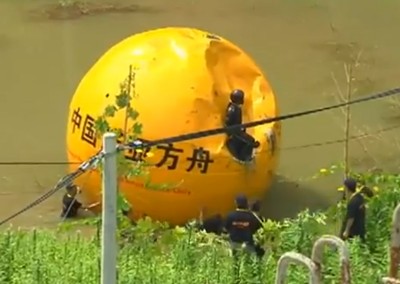 While you're toasting the end of the world tonight in Seattle, a man in China is hiding out in a giant yellow ball. (Screenshot via youtube.com)