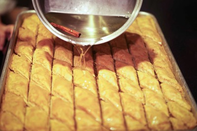 The final step to making baklava: pouring on the simple syrup. (Photo by Christof Dreyer)