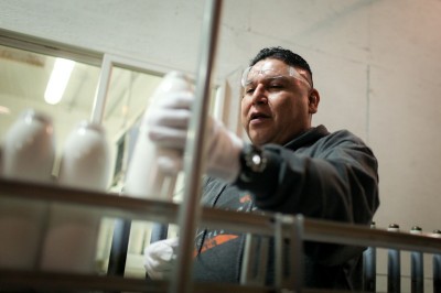 Tony Morales, a longtime employee, handles bottles on the line at Liberty. The company says they're able to compete with cheaper Chinese labor through advanced mechanization and lower shipping costs. (Photo by Alex Stonehill). 