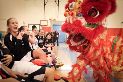 Chief Sealth Junior Allison Steele is teased by a Chinese Dragon during a performance from the David Leong Kung Fu studio. The dance opened an exhibition game between the Nankai High School and Chief Sealth girls basketball teams. (Photo by Alex Stonehill)