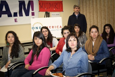 Jenesis Garcia (far left) and others watch the State of the Union address with some skepticism at a watch party held by SEIU and OneAmerica. (Photo courtesy OneAmerica)