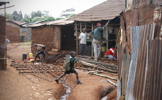 A wall is constructed to an existing building in Kibera. Some development workers are pushing for improvements of existing infrastructure, instead of brand new buildings. (Photo by Alex Stonehill)