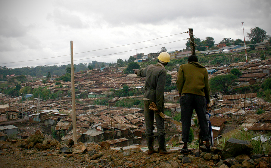 Gordon (left), a construction worker and resident of the Kenya Slum Upgrading Project, points to where his home was demolished to build a road along the back of Kibera. Demolition is a regular part of life in the slum, as residents, classified as squatters by the government, have little to no housing rights. (Photo by Abby Higgins)