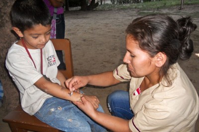 Marta, a health promoter with Etta Projects in Bolivia, cares for a local child. (Photo courtesy Etta Projects)