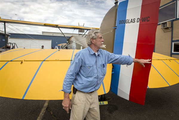 Bob Dempster pushes over the rudder of The Seattle II, a Douglas World Cruiser replica built nearly from scratch that he and his wife, Diane, intend to fly around the world. (Photo by Steve Ringman / The Seattle Times)