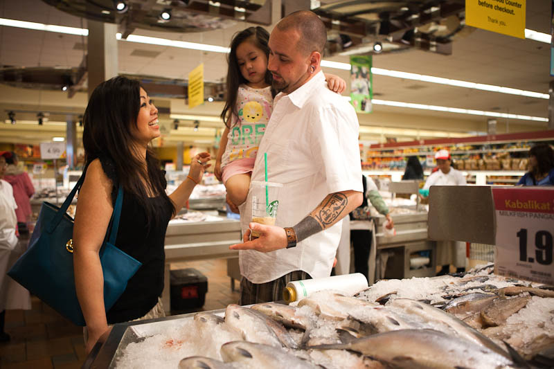 Sopheary Hermens (left) whose parents immigrated from Cambodia and Thailand, with her husband Damien and their daughter Neilah, at the Seafood City Supermarket in Tukwila. (Photo by Ian Terry)