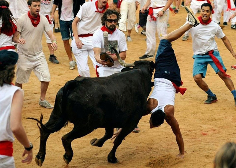 Matthew ‘Griff’ Griffin attempts to hang a pair of his Combat Flip Flops on the horns of a bull in Pamplona. (Photo from Reuters/Eloy Alonso)