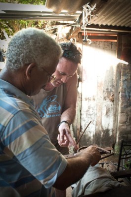 Blacksmith Ernesto Muñoz shows Northwest native Del Morris how to craft a scroll out of metal in his workshop in Cartagena. (Photo by Wesley Tomaselli)