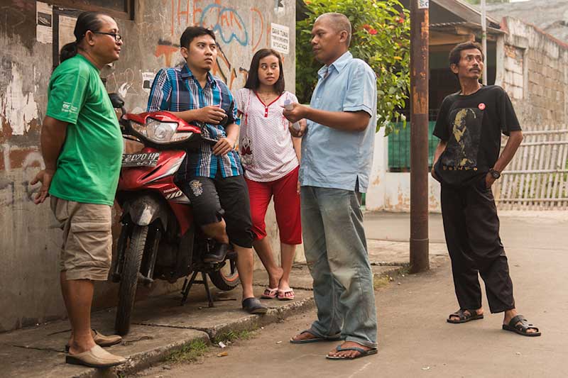 Anissa (center) and her husband (second from left) with fellow workers and union leaders in a Northeast Jakarta neighborhood near the factory where they work. (Photo by Branden Eastwood)