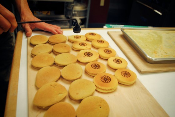 Art Oki meticulously prepares dorayaki, a cake-flour dessert with red bean paste, branded with an emblematic chrysanthemum.  (Photo by Anna Goren)
