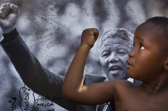 A young boy from the Maitibolo Cultural Troupe pays tribute to former South African President Nelson Mandela in Pretoria, South Africa. (Photo by Ben Curtis/Associated Press)