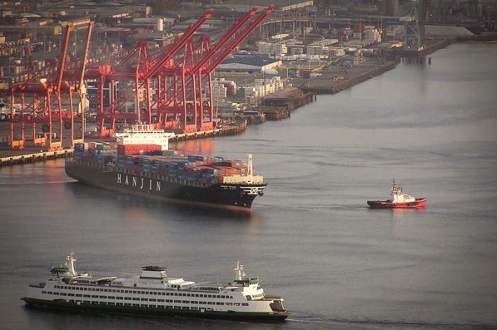 A container ship leaves the Port of Seattle while the Bainbridge Island ferry enters. (Photo via Wikipedia)