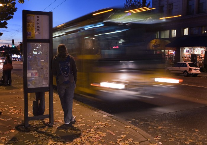 A rider waits at a bus stop in Seattle. 
