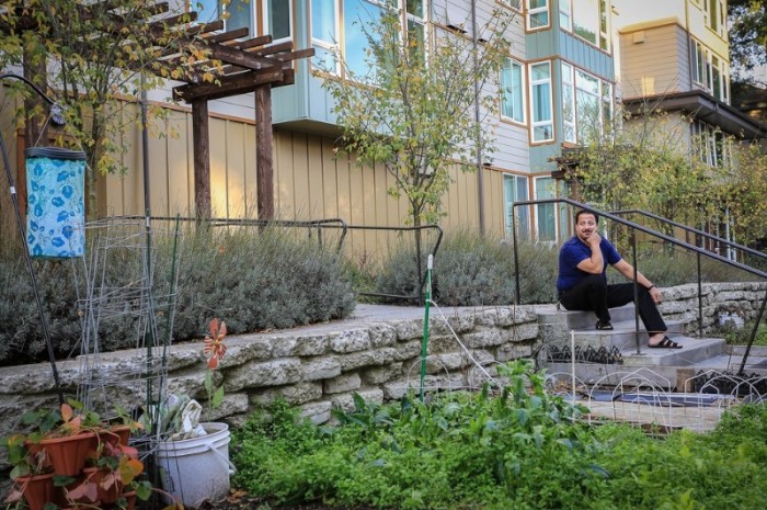 Amer Kuba sits outside his home in North Seattle (Photo by Laura Huysman)