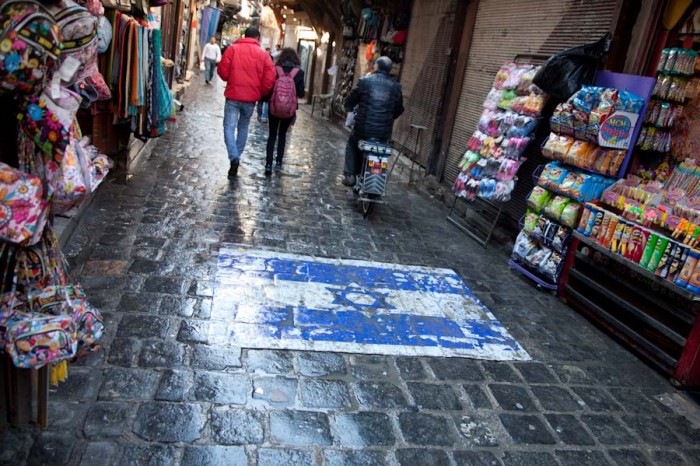 An Israeli flag painted on the ground on a busy street  in Damascus symbolizes the Syrian government's longstanding use of enmity with Israel as a nationalist rallying point. (Photo by Alex Stonehill)