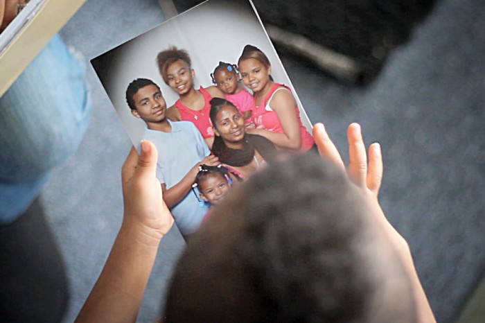 Dede Adhanom's son King holding family photo in a still from "Unified Struggle." (Courtesy of Guerrilla Films)