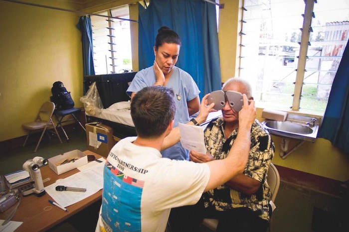 A medical interpreter assists a patient in Tonga during an eye exam. (Photo by Mass Communication Specialist 2nd Class Joshua Valcarcel / U.S. Navy)