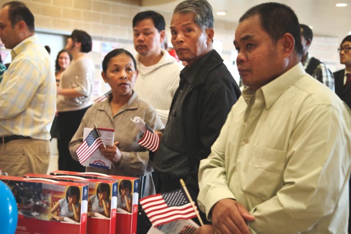 In line at a citizenship swearing in ceremony in Tacoma. Immigrants and new citizens are disproportionately targeted by criminals and scammers, advocates say. (Photo by Alex Stonehill)