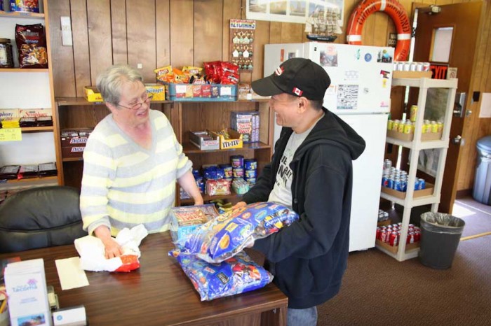 Betty Erichsen, a volunteer at the Tacoma Seafarers' Center, helps Filipino seafarer Rommel Quibaez with a bulk candy bar purchase. Seafarers are typically in port for about 12 hours only once every few weeks, so an opportunity to stock up on essential items is welcome. (Photo by Alex Stonehill)