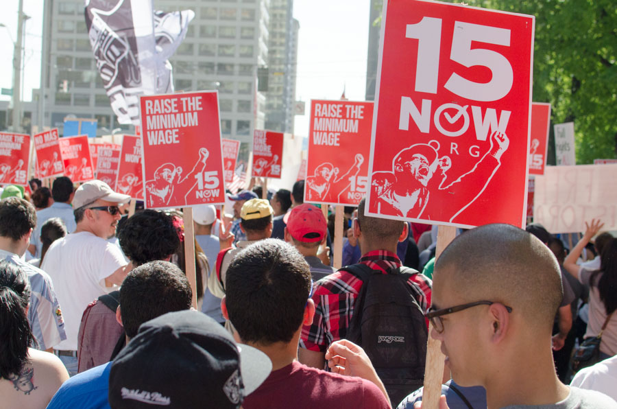 Nearly 10,000 showed up the May Day march with signs and flags, calling for a higher minimum wage and an end to discrimination against immigrants. (Photo by Seth Halleran)