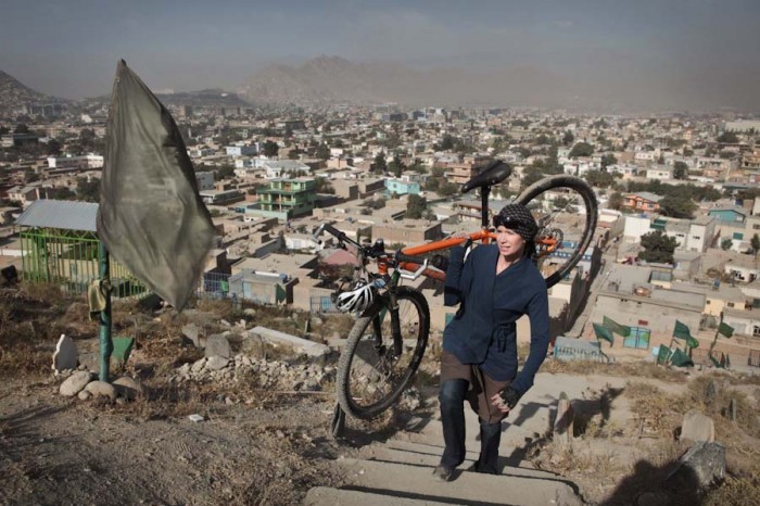 Shannon Galpin carries her bike up a hill outside Kabul. (Photo courtesy mountain2mountain.org)