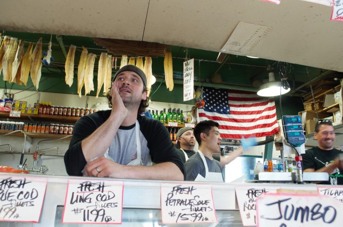 Anders Miller, assistant manager at Pike Place Fish Market, yells to encourage people to buy fish. (Photo By LaVendrick Smith)