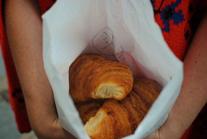 The author holds a bag of croissants, still cheap in an otherwise exorbitant country. (Photo by Molly Goren).