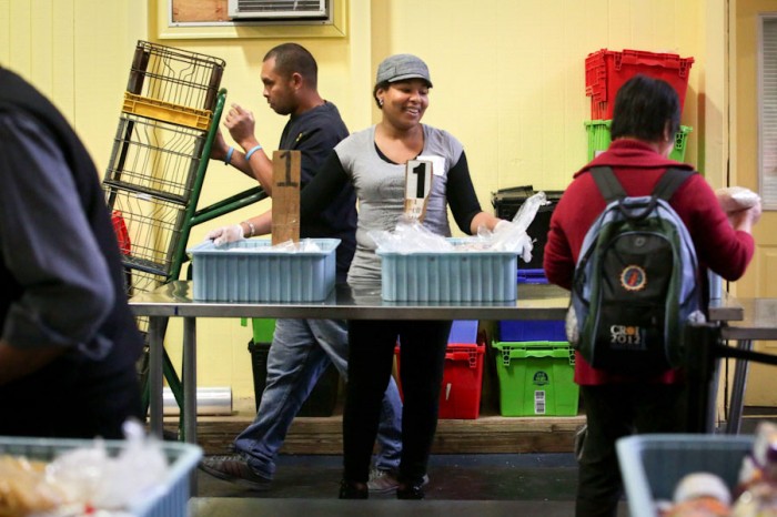 Volunteer Cathy Hamilton (center) distributes goods at the Cherry Street Food Bank  in Seattle. Hamilton said the clientele at the food banks is incredibly diverse- young, old, White, Asian, African, Black, Hispanic, families and the disabled. (Photo by Erika Schultz / The Seattle Times)