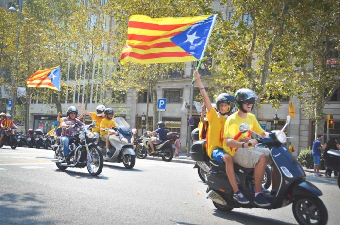 A motorcade flying Catalonian flags passes through the streets of Barcelona. With a strong economy and a unique language and culture, many Catalonians want to see their region secede from the rest of Spain. (Photo by Seth Halleran)