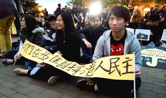 UW students sitting with solidarity signs at a Hong Kong support protest in Red Square Wednesday night. (Photo by Gennie Gebhart)