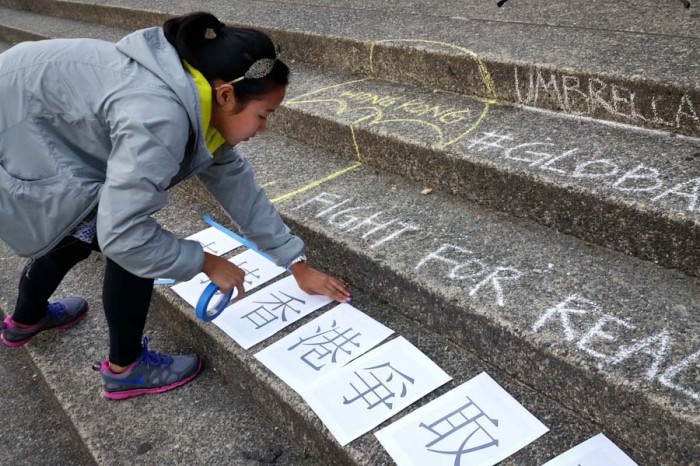 Taping signs to the steps in Red Square. (Photo by Gennie Gebhart)