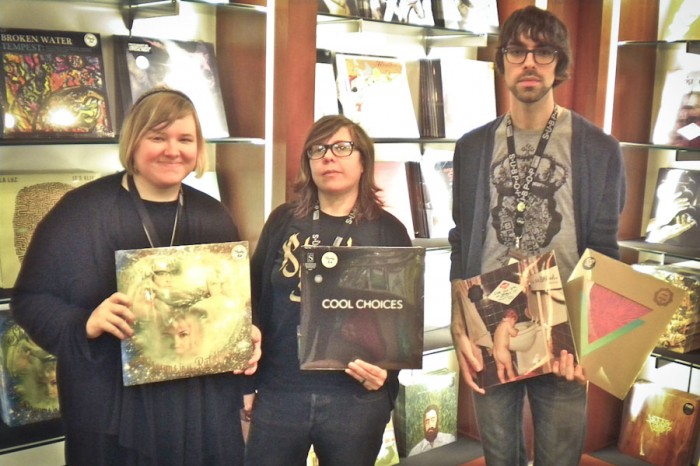 Sub Pop's Sea-Tac gift shop staff picks, from left: Sarah Cass with "Dreams in the Rat House" by Shannon and the Clams; Rachel Rhymes with "Cool Choices" by S; Jacob Powers with "Bakesale" by Sebadoh and "Commune" by Goat. (Photo by Charlie Zaillian)