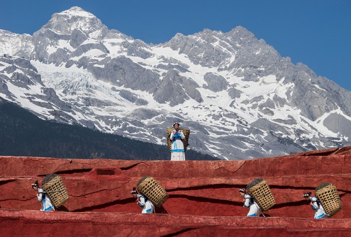 Naxi women carry their traditional baskets in Lijiang, Yunan Province with Yùlóngxuě Mountain standing behind them. The Naxi tribe is one of up to 100 ethnic groups in China, of which 56 are recognized by the Chinese government. (Photo from Wikimedia Commons)