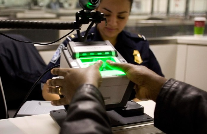 An international visitor arriving at Washington Dulles Airport is fingerprinted as part of a system to track undocumented immigrants and prevent visa overstays. (Photo by Dept. of Homeland Security)