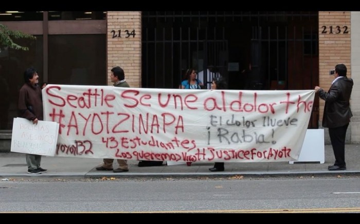 Protesters in front of the Consulate General of Mexico in Seattle demonstrate solidarity alongside the 43 missing students in Mexico and their loved ones. (Photo from Sarahy Sigie's documentary video, Seattle Is With Ayotzinapa's Pain)