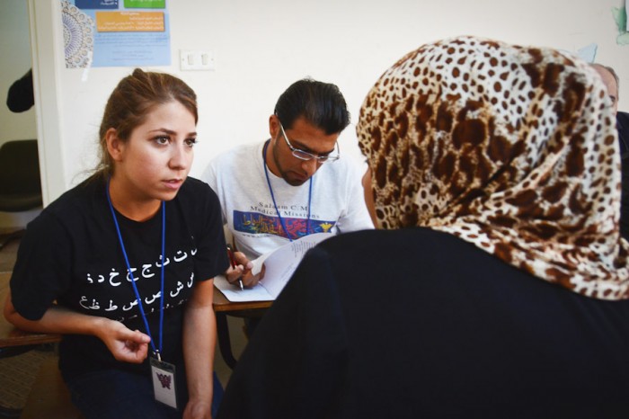 Reham Hamoui interprets for a Syrian refugee at a pop-up clinic held during the Seattle-based Salaam Cultural Museum's week-long aid mission in Jordan in September. 