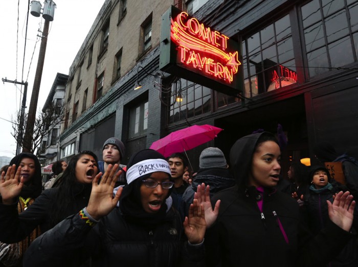 Chanting "hands up, don't shoot," protesters briefly blocked the entrance to the Comet Tavern on Black Friday, saying that the business owners discriminated against East African youth. (Photo by Alan Berner / The Seattle Times)