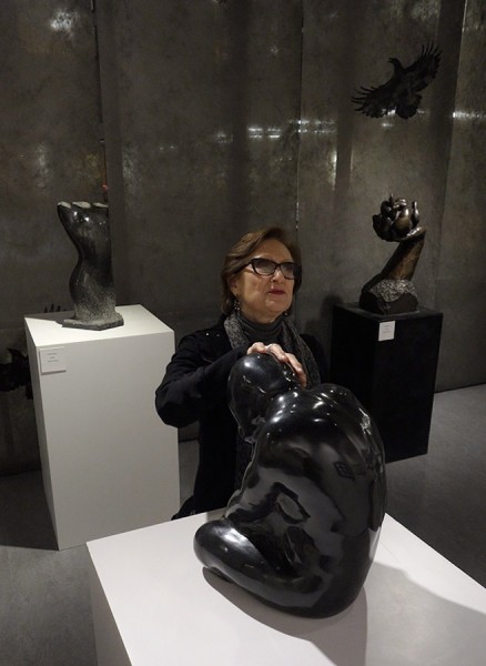 Camille Jassny, who is blind, touches "Quiet Moment" , a basalt sculpture created by Sabah Al-Dhaher. In the background at left is Sabah's "Female Torso" a basalt piece and to the right, background is Sabah's bronze piece "Beginning." These are part of a current show titled Please Touch which is showing at the Edmonds Community College library gallery. (Photo by Jim Ballard)