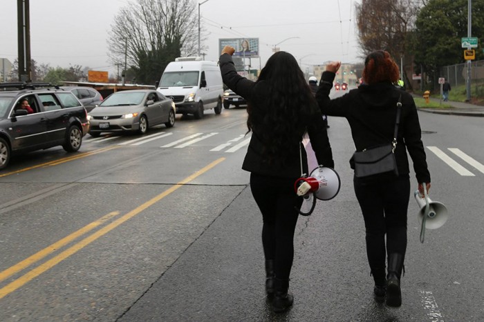 Aretha Basu and Harmony Wright marching along Martin Luther King, Jr. Way during their Jan. 10th protest. (Photo by Naomi Ishisaka)