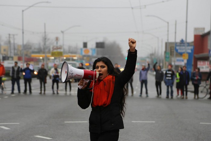 Aretha Basu leads a chant on Rainier Avenue South and Dearborn Street during their Jan. 10 police accountability protest. (Photo by Naomi Ishisaka)