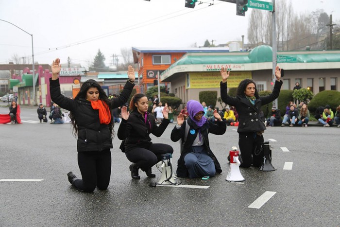 Basu, Wright, Ahmed and Canez lead the "Hands up! Don't shoot!" chant on Jan. 10 with protesters gathered round on the corner of Rainier Avenue South and Dearborn Street. (Photo by Naomi Ishisaka)