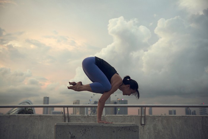 A woman practices the crow yoga pose 