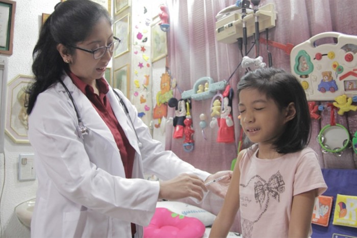 A doctor vaccinates a young girl. (Photo by Gabriel Pagcaliwaga for Sanofi Pasteur, via Flickr)