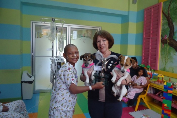 A volunteer brings therapy dogs to a pediatric cancer center in Guatemala. Photo by Fundación Ayúdame a Vivir via Facebook.