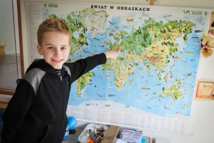 Fourth grader Arthur Gwozdz of Newcastle points at his parents’ native Poland on a map in his family’s living room. Gwozdz was one about 100 youth who took part in the Washington state level of the National Geographic Bee at PLU on Friday. (Photo by Kyle Haddad-Fonda)