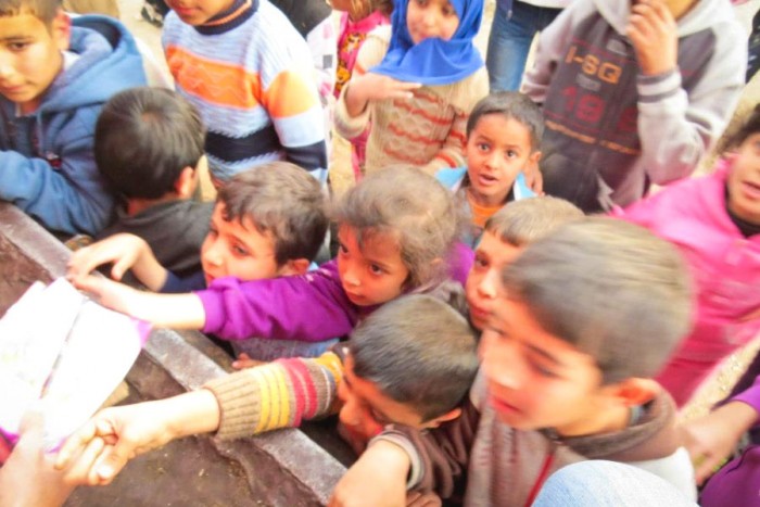 Children in a camp for Syrian refugees clamor for aid distributed by SACCWA. (Courtesy photo)