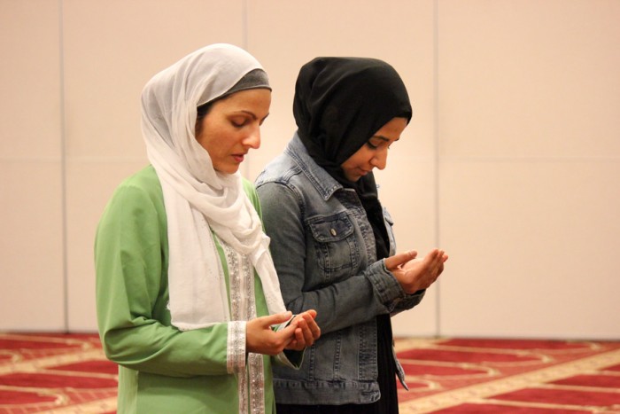 Aneelah Afzali (left) and her friend, Roya Jalili, pray at the Muslim Association of Puget Sound (MAPS) mosque in Redmond. (Photo by Ashley Walls.)